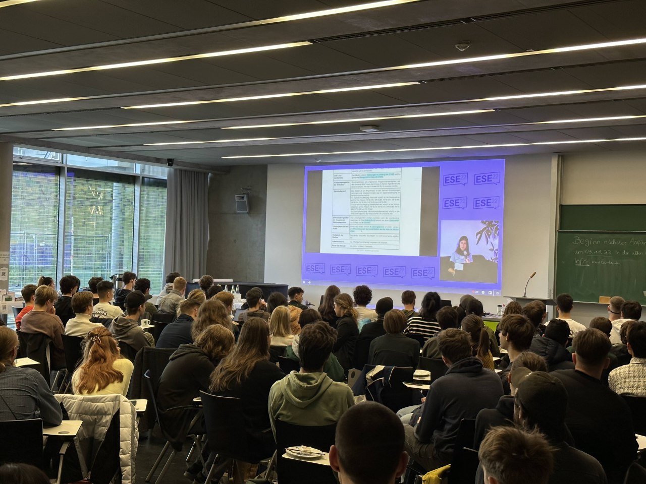 Viele Studierende sitzen in einem Raum. Es gibt eine Präsentation mit Informationen zur ESE.